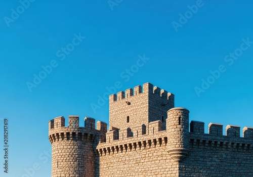 Massive stone castle walls featuring crenelated parapets under a bright blue sky, highlighting historical defensive architecture and fortification structure, rectangular, exterior, geometry
