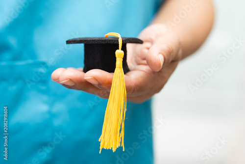 Asian doctor study learn with graduation gap hat in hospital ward, clever bright genius education medicine concept.