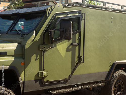 Side View of Olive Green Armored Military Vehicle with Reinforced Doors and Bulletproof Windows