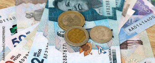 Colombian peso money bills and coins on table. Colombia cash of COP currency close up