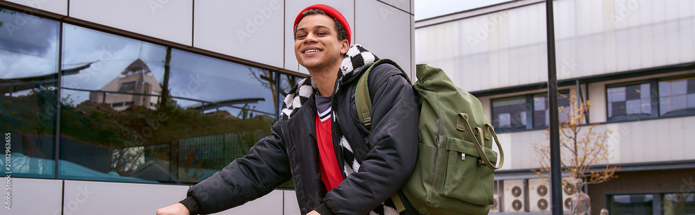 Fototapeta premium Stylish young man enjoys a vibrant day in the city as he rides his bike to class