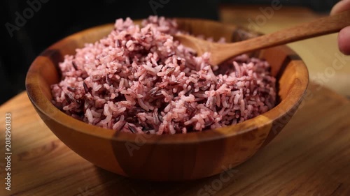 Cooked Riceberry Rice in a Wooden Bowl with Wooden Spoon on a Wooden Table