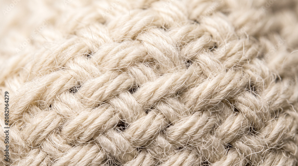 Fototapeta premium Close-up texture of natural cashmere wool knit fabric, cozy beige background pattern