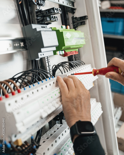 smart home, connecting wires in the electrical box, close-up of a wire with pliers
