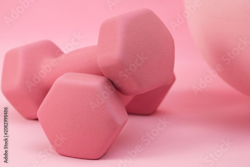 Close up pink dumbbells on pastel background for feminine workout