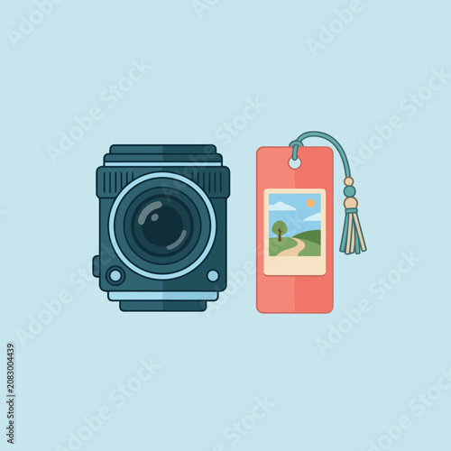 A digital camera lens sits beside a decorative paper bookmark