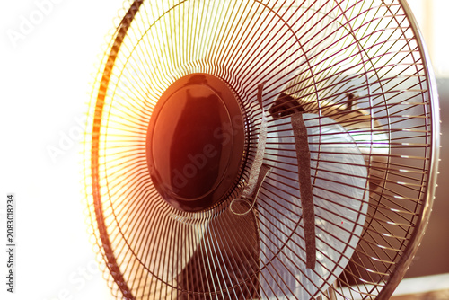 Fan spins in a room as the air circulates over surfaces and creates movement during a warm afternoon in summer