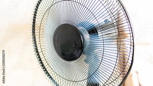 Fan spins in a room as the air circulates over surfaces and creates movement during a warm afternoon in summer