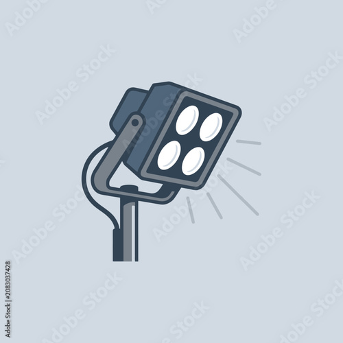 A modern studio spotlight stands on a sturdy metal tripod base