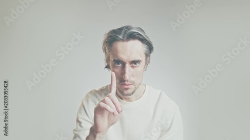Serious adult man making gesture no denial shakes head no  looking at camera in neutral studio, soft diffused lighting, shallow depth of field, communication concept