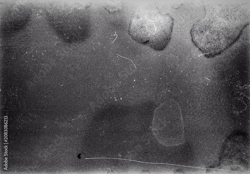Blank grained film strip texture background with heavy grain, dust and light leak. Old expired soviet moldy photographic film scan. Black and white.