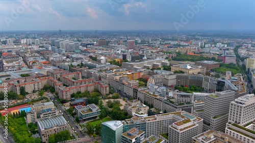 Aerial drone view of dense modern office buildings, green roofs, and residential blocks near Potsdamer Platz in Berlin Mitte, Germany, summer daytime.