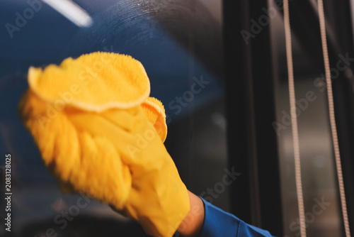 Person cleaning the room, cleaning staff is using cloth and spraying disinfectant to wipe the tables in the company office room. Cleaning staff. Maintaining cleanliness in the organization.
