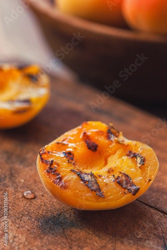 Freshly grilled apricots with honey on the wooden background