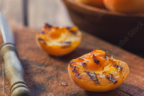 Freshly grilled apricots with honey on the wooden background