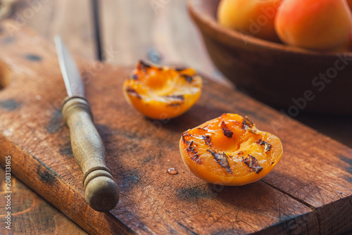 Freshly grilled apricots with honey on the wooden background