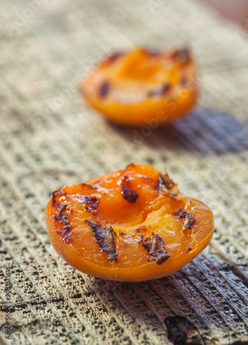 Freshly grilled apricots with honey on the wooden background