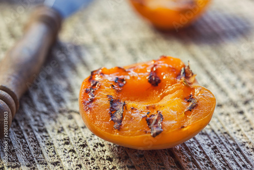 Freshly grilled apricots with honey on the wooden background