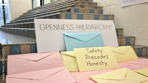 Colorful Envelopes Displayed on Steps with Signage about Openness and Honesty in a Bright Indoor Space