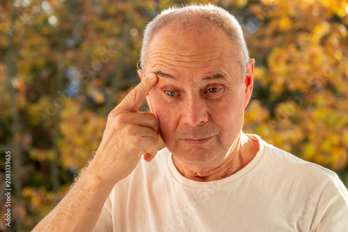 Tableau sur toile mature male face man 50-55 years old, looks examines wrinkles around eyes, skin