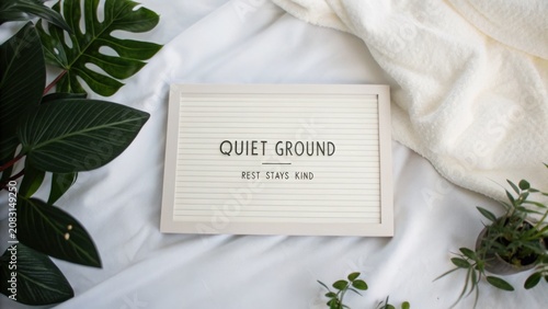Tranquil Space with Relaxing Message on Letter Board Surrounded by Green Plants and Cozy White Textiles for Peaceful Ambiance