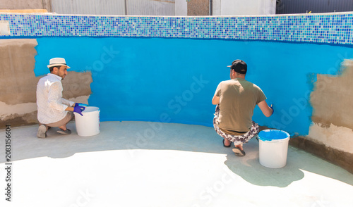 Paints the pool with blue paint. Selective focus.