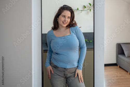 Foto Happy plus size woman smiling near mirror