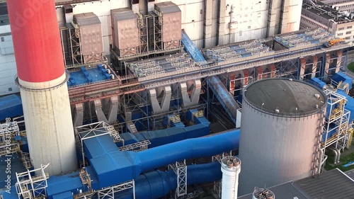 Aerial view of an industrial plant showcasing the continuous layout of blue structures, smokestacks, and piping systems, emphasizing the intricate design of the factory environment