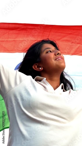 Holding Indian Flag, Cheerful Teenage Girl Standing in Open Air as Tricolour Flutters in the Wind, Happy Asian Child Displaying National Pride and Patriotism Under Blue Sky with Joyful Expression