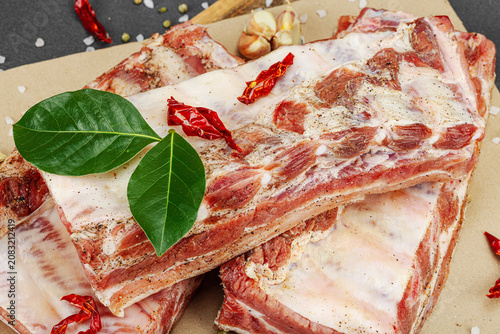 Raw marinated pork ribs prepared for BBQ picnic with spices, garlic and bay leaves