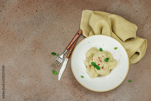 Traditional Ukrainian vareniki or pierogi with mint leaves and spices served on a ceramic plate