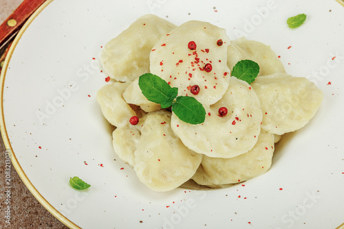 Traditional Ukrainian vareniki or pierogi with mint leaves and spices served on a ceramic plate