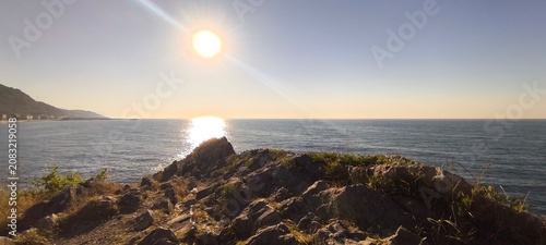 Fotografie A serene seascape with the sun’s reflection shimmering on the calm waves, accomp