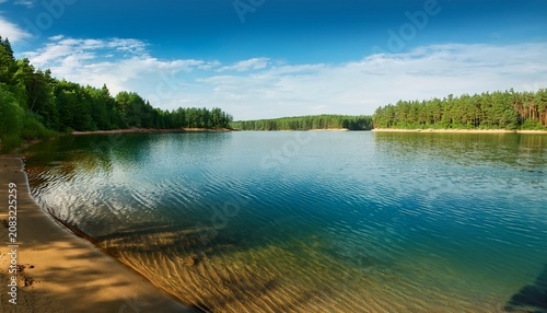 calm lake water with gentle ripples near sandy shore surrounded by green forest peaceful summer landscape perfect for relaxation nature travel and outdoor recreation concepts