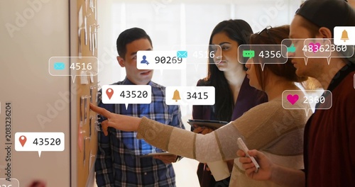 Принти на полотні Marketing team pointing at board while icons flowing from left responding and hi