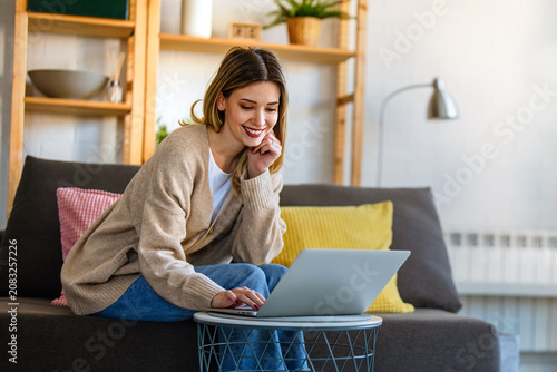 Young female designer, freelancer working in the office. Female using laptop to searching info.