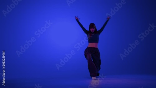 Urban dance woman performing in blue studio