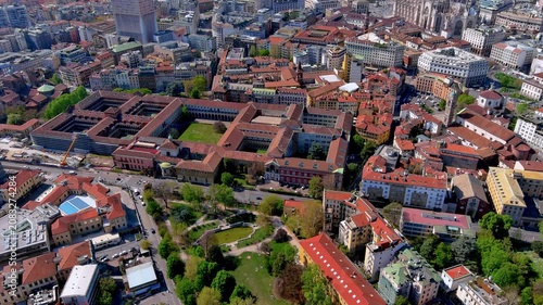 Aerial drone view of the University of Milan Ca' Granda renaissance courtyards, Guastalla Gardens, and Milan Cathedral behind, Lombardy, Italy, spring daytime.