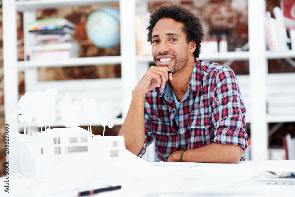 Naklejka premium Property development, portrait or black man in office with model, pride or urban planner in building project. Happy, layout or person with confidence, architect or about us as infrastructure engineer