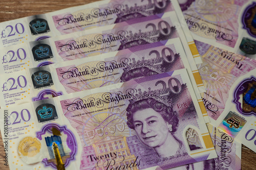 Colorful British currency stacked elegantly on a wooden surface showcasing intricate designs and royalty
