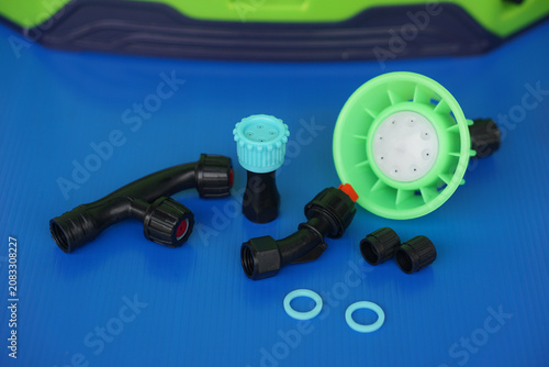 Agricultural sprayer accessories and replacement nozzle parts on a blue background. Plastic spray components for farming, gardening, irrigation, maintenance, and plant protection equipment.