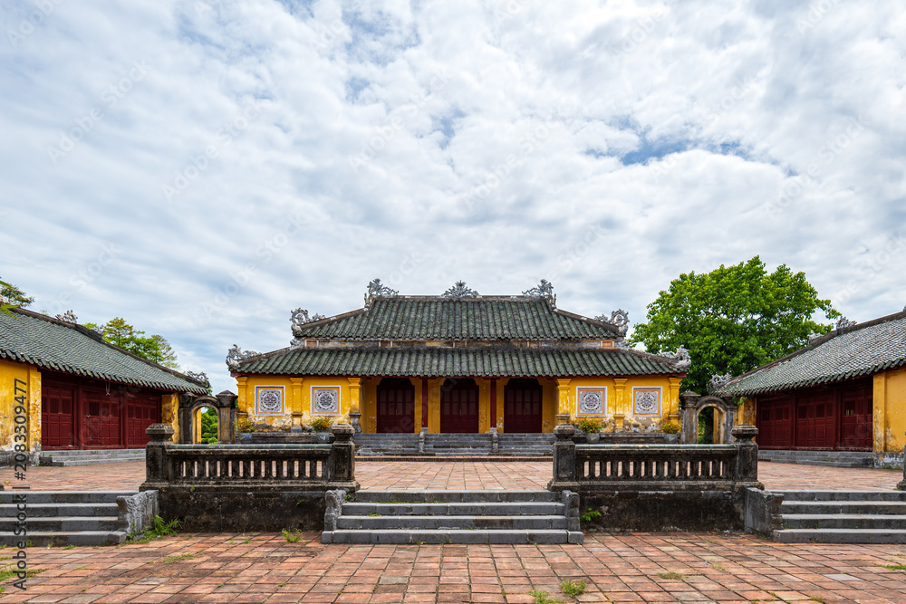Fototapeta premium Nguyen dynasty palace courtyard with yellow buildings and tiled roof at Hue Imperial Citadel, Vietnam