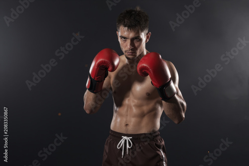Powerful Boxer in Red Gloves Ready for Combat Against Dark Background, Generative AI