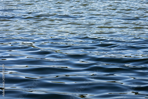 Cuadro en lienzo Blue lake water undulates in layered lines reflecting sky and shore creating a c