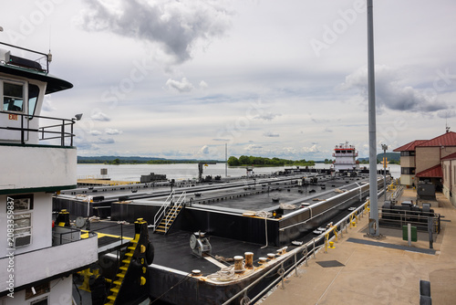 A barge with a load of oil passing through a lock and dam on the Mississippi River.