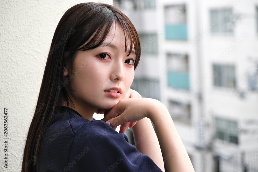 Fototapeta premium ベランダから見える景色を眺めて休憩する女性