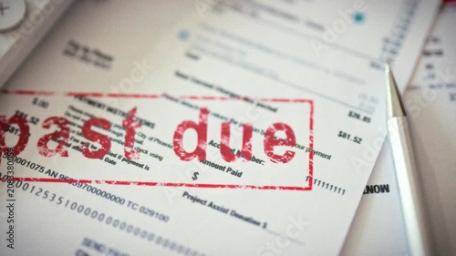 A view captures a receipt marked with a red seal bearing the inscription past due, denoting unpaid utilities. The stamped payment slip rests among documents and a calculator, showing overdue bills