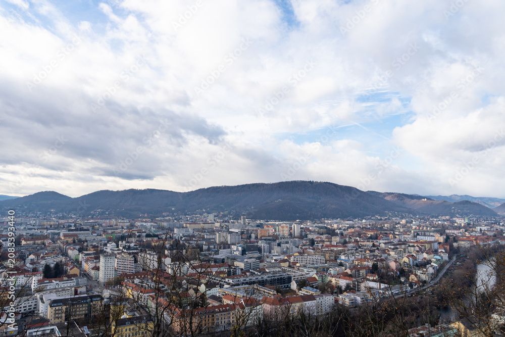 Fototapeta premium City Skyline with Hills Under Dramatic Cloudy Sky Panorama