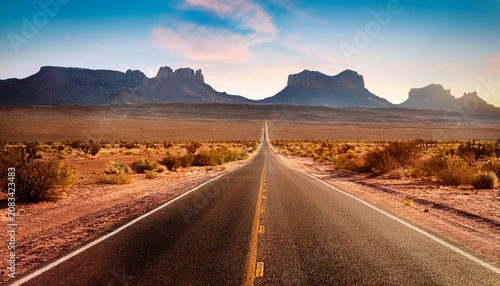 a long road in the desert heading towards the mountains an image that conveys themes of journey freedom and the future