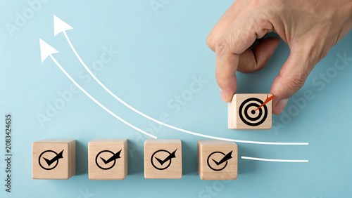 Hand placing a wooden block with a target icon on a growth chart background